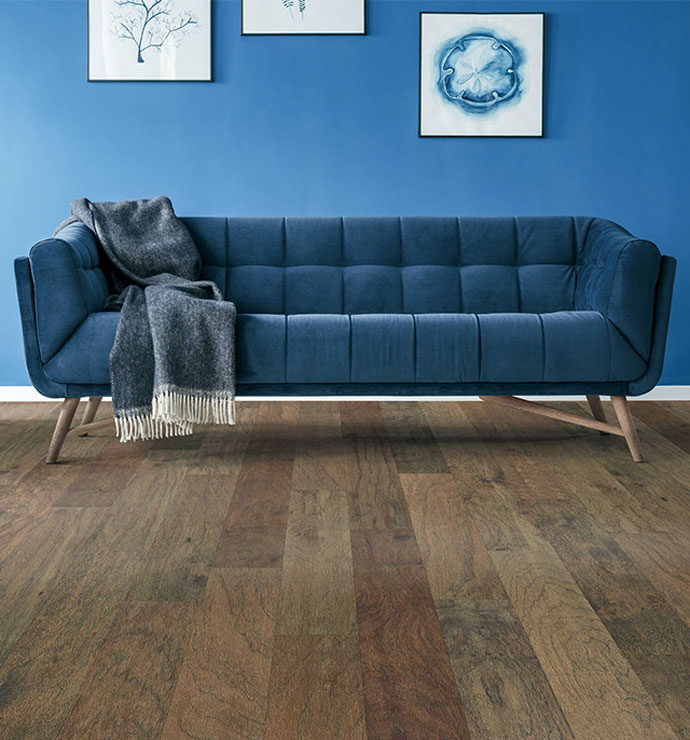 Blue couch on hardwood flooring | Emo Flooring company
